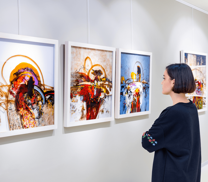 Woman admiring abstract paintings in gallery